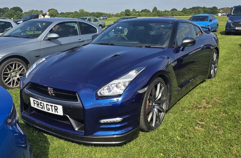 Blue 2012 Nissan GT-R Premium Edition (R35) parked on grass.