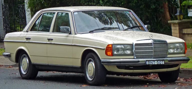 Cream Mercedes-Benz 280 E W123 sedan parked at the curb