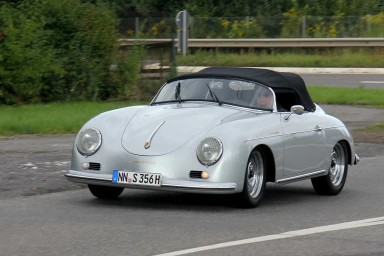 Silver Porsche 356 A Speedster driving on a country road