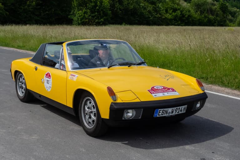 Yellow Porsche 914/4 driving on a country road