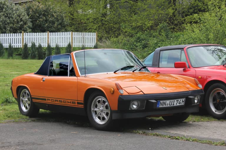 Orange Porsche 914 targa parked on grass