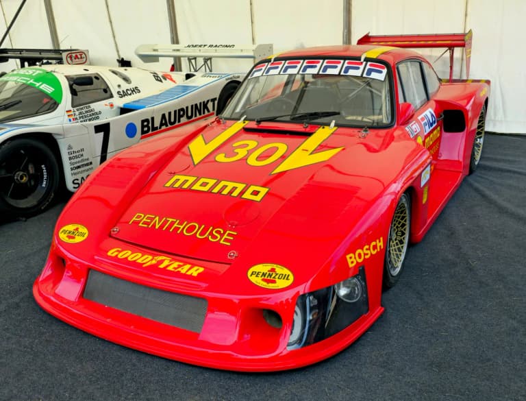 Red slant-nose Porsche 935 race car with large rear wing