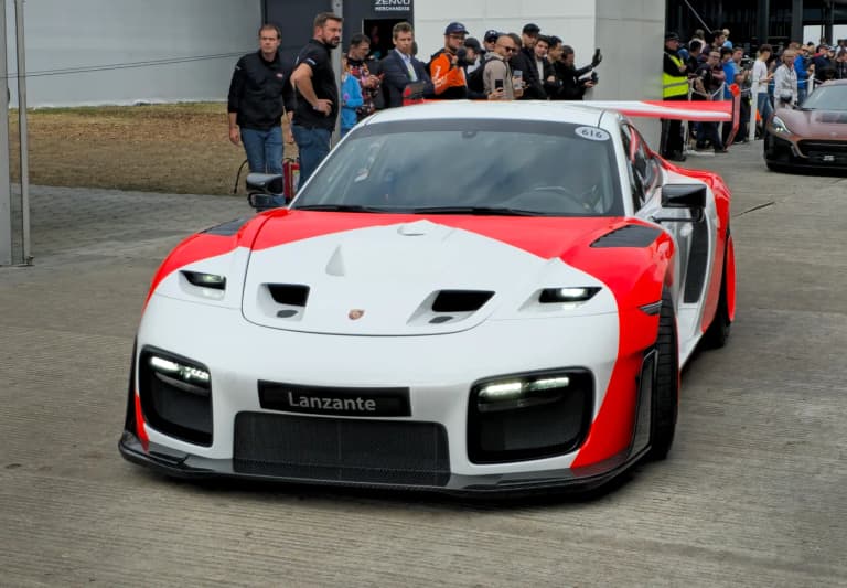 Modern 2018 Porsche 935 in white and red livery at a track event