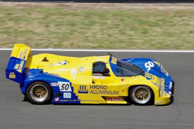 Yellow and blue Hydro Aluminium Brun Porsche 962C number 50 racing on track