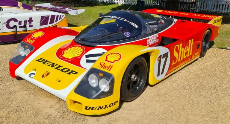 Red and yellow Shell Dunlop Porsche 962C number 17 parked at a concours