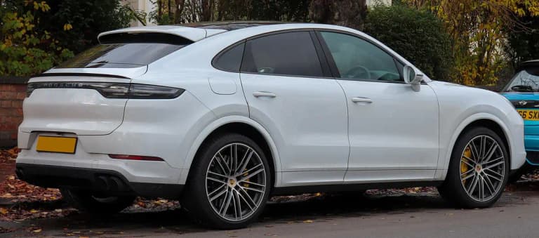 White Porsche Cayenne Coupe Turbo rear three-quarter view with adaptive spoiler