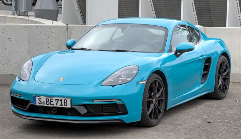 Blue Porsche 718 Cayman GTS, side profile in an urban setting