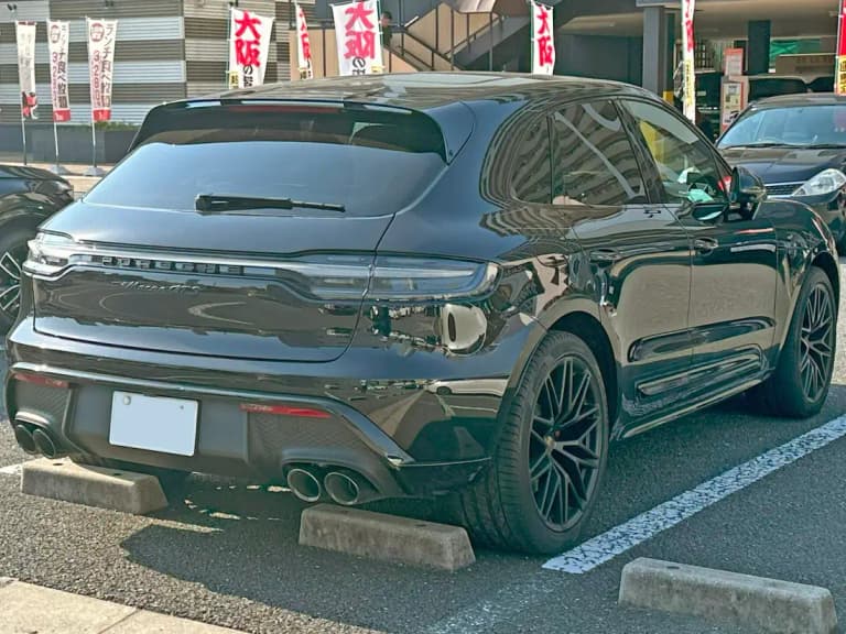 Black Porsche Macan GTS rear showing tinted tail light bar and black exhaust tips
