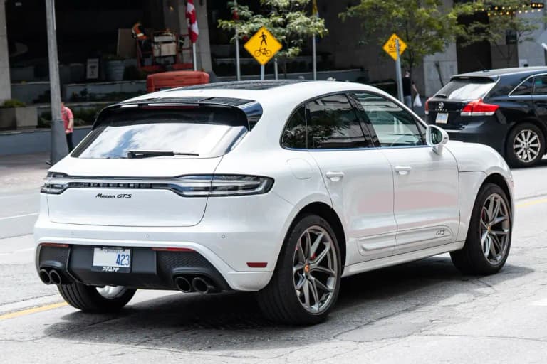 White Porsche Macan GTS rear three-quarter showing the Sport Design rear bumper