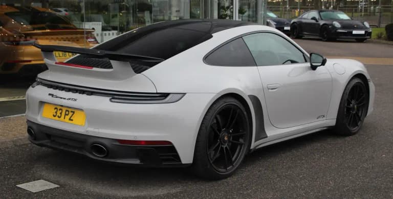 Grey Porsche 992 911 Carrera GTS rear three-quarter view with rear wing