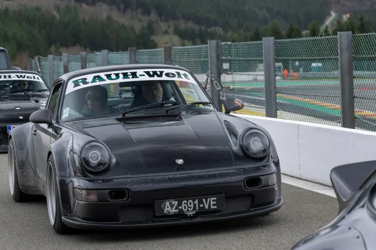 Black RWB Porsche 964 with wide arches on a racetrack at Spa