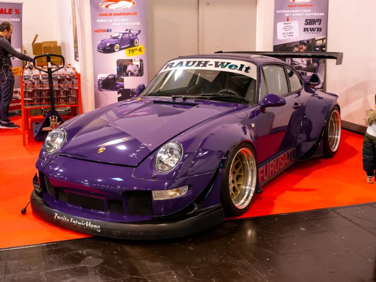 Purple RWB Porsche 993 named Furusato with Rauh-Welt banner and gold wheels