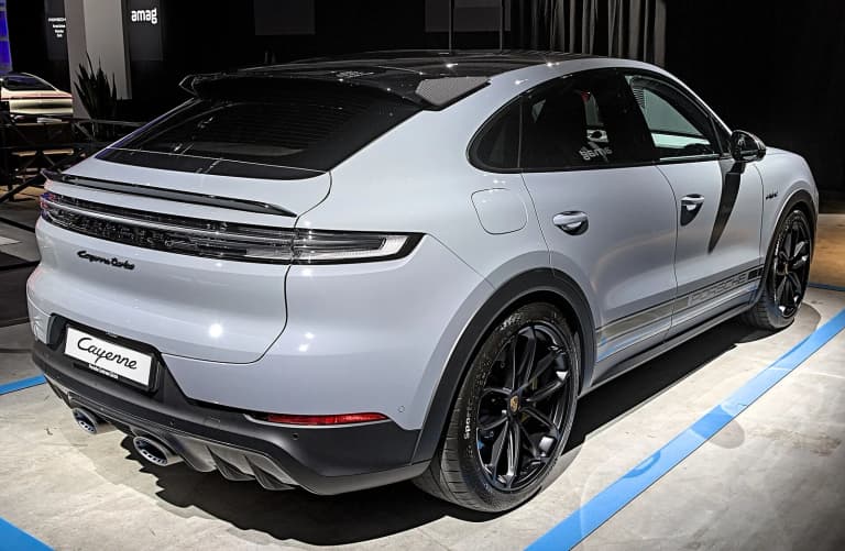 Grey Porsche Cayenne Turbo S E-Hybrid Coupe with carbon roof, rear three-quarter view