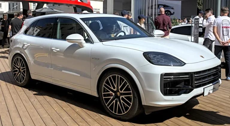 White Porsche Cayenne Turbo E-Hybrid, front three-quarter view at an auto show