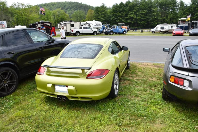 White Porsche Cayman R in front three-quarter view at a track event.