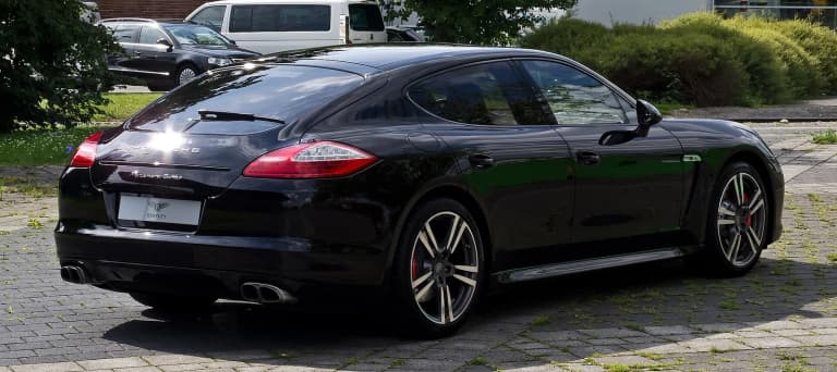 Rear of a black first-generation Porsche Panamera Turbo, showing its rounded tail.