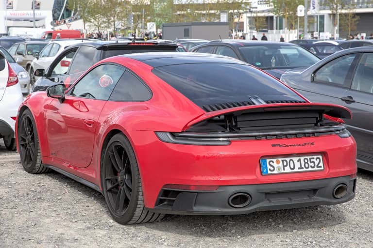 Porsche 992 Carrera GTS rear three-quarter view with the active rear spoiler raised