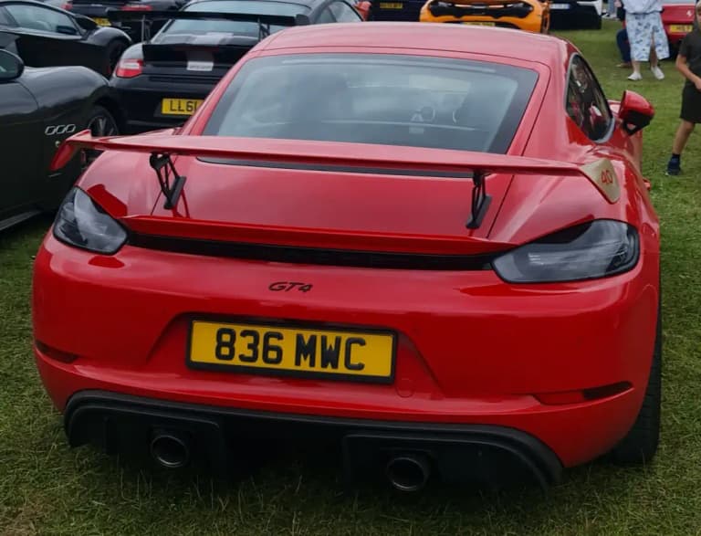 Red Porsche 718 GT4 rear view with fixed wing and 4.0 badge