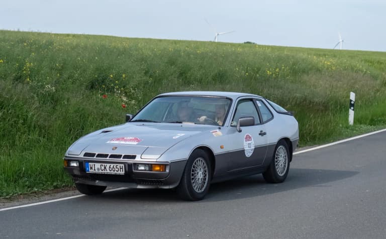 Silver Porsche 924 Turbo driving on a country road