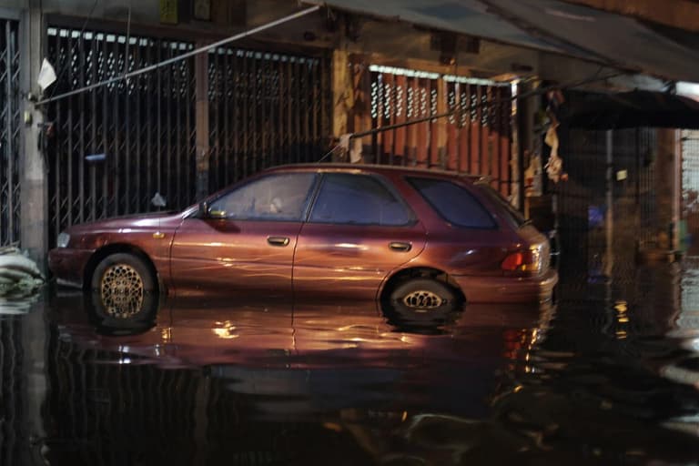 Car sitting in floodwater up to its doors on a Bangkok street