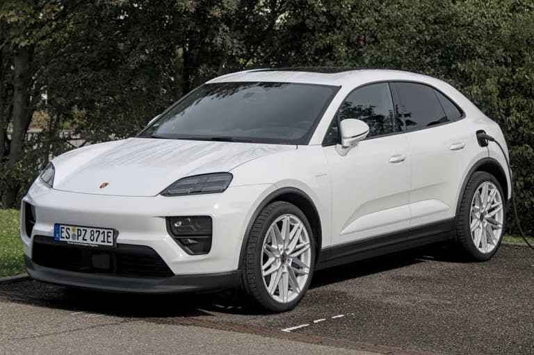 White 2024 Porsche Macan 4 electric SUV in a bright outdoor setting