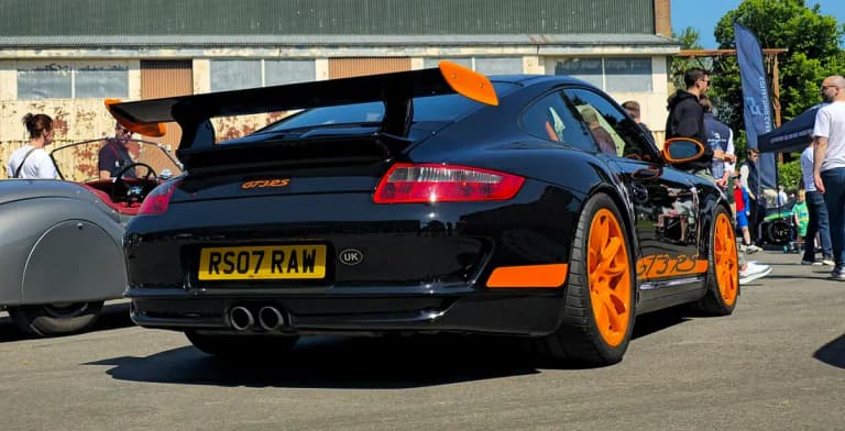 Black Porsche 997 GT3 RS with orange accents, powered by the naturally aspirated Mezger engine flat six