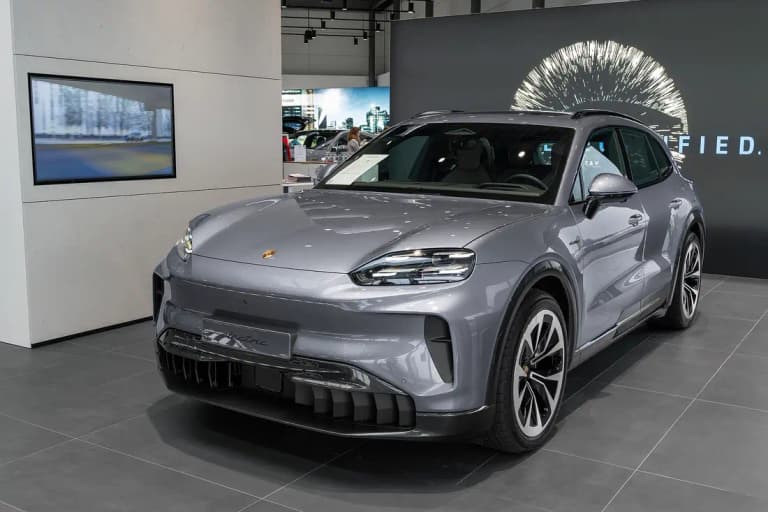 Grey Porsche Cayenne Electric on a show stand, front three-quarter view