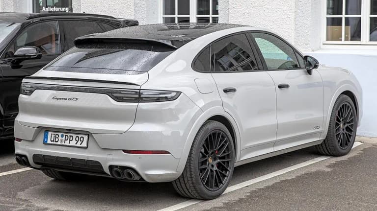 Chalk gray Porsche Cayenne GTS Coupe, rear three-quarter view with black wheels