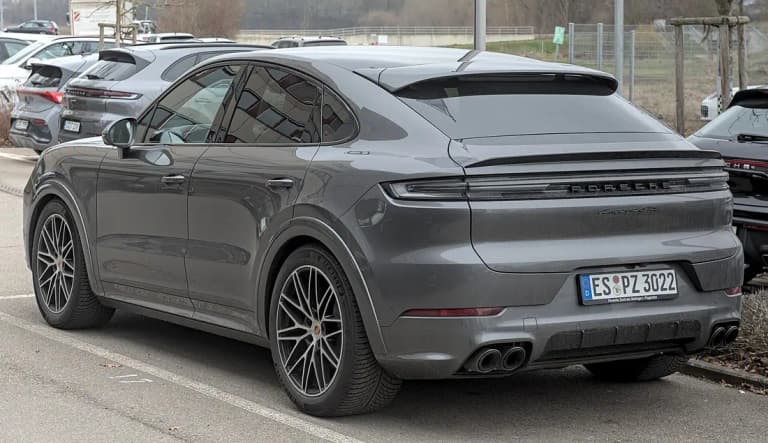 Gray Porsche Cayenne GTS Coupe, rear three-quarter view showing the light bar and quad tailpipes