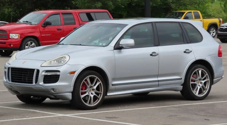 Silver first-generation Porsche Cayenne GTS SUV, front three-quarter view with red brake calipers