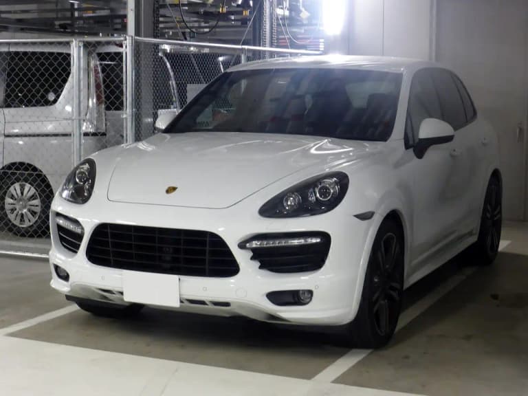 White second-generation Porsche Cayenne GTS SUV, front three-quarter view in a parking garage