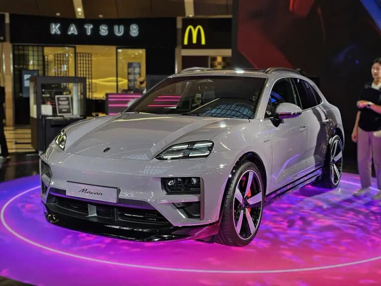 Gray Porsche Macan EV front three-quarter view on show stand