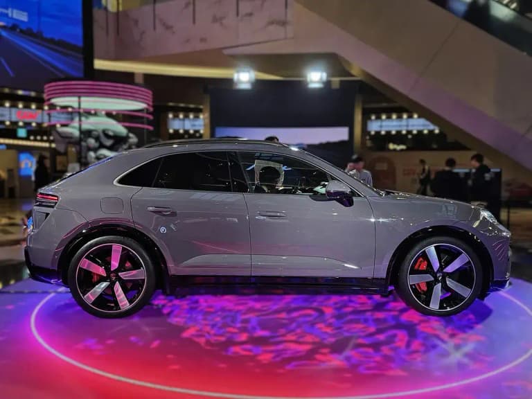 Gray Porsche Macan EV side profile with electric badge and low roofline