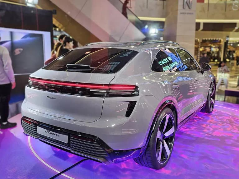Gray Porsche Macan EV rear three-quarter view showing the coupe-like roofline