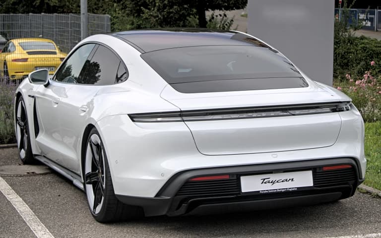 White 2024 Porsche Taycan sedan, rear three-quarter view