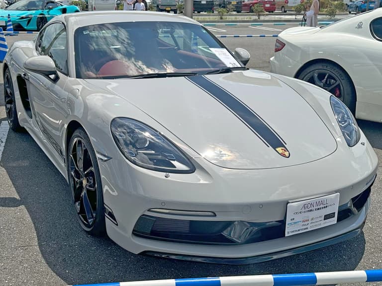Gray Porsche 718 Cayman Style Edition with black hood stripes, front three-quarter view