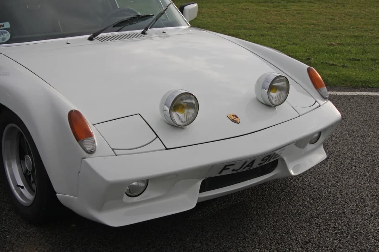 Porsche 916 front detail showing its fiberglass bumper cover, air dam, oil-cooler opening, and recessed driving lamps