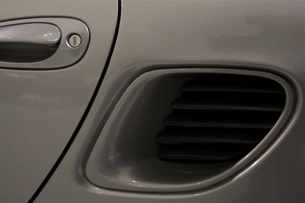 Close view of a Porsche 986 Boxster side engine-air intake behind the door
