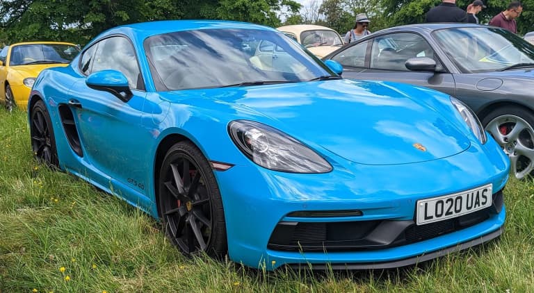 Blue Porsche 718 4.0-liter GTS in front three-quarter view at a car meet