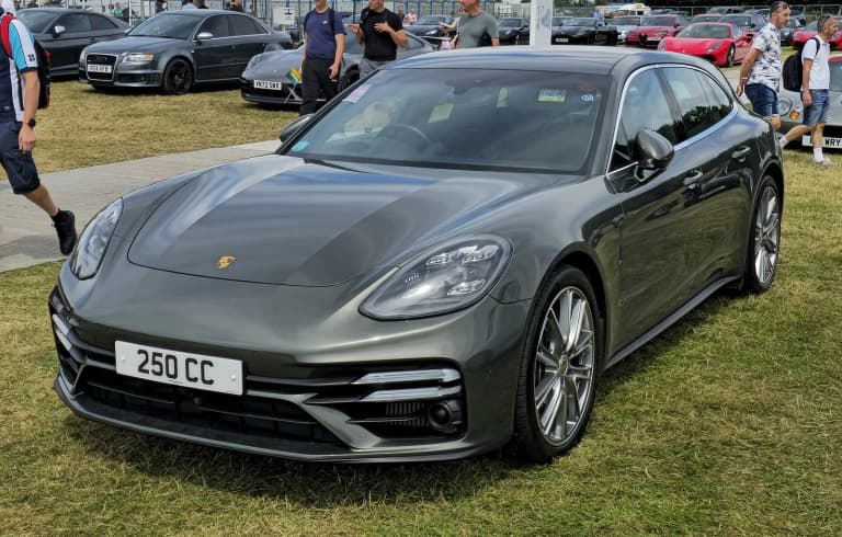Dark gray 2021 Porsche Panamera Turbo S Sport Turismo at a car event.
