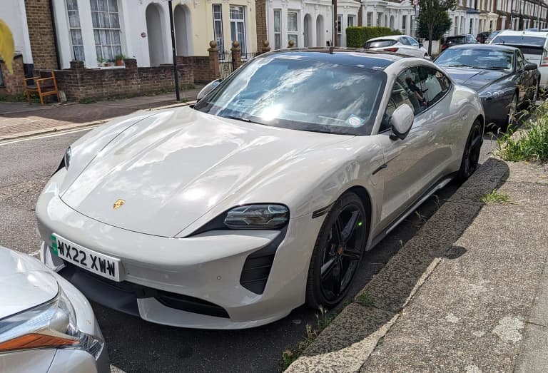 White Porsche Taycan Turbo sedan parked on a residential street.
