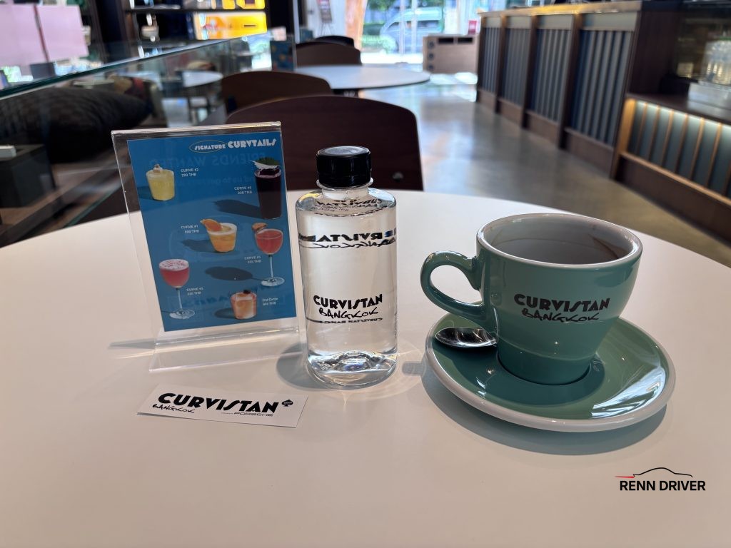 Bottle of water coffee and sticker from Curvistan the Porsche cafe