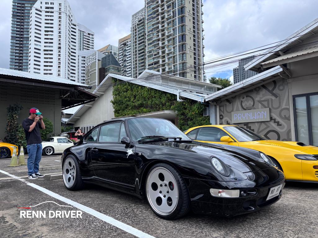 Black 993 Carrera on aero wheels, front three-quarter view at meet.