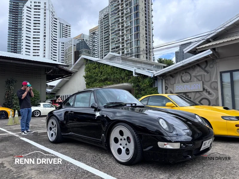 Black 993 Carrera on aero wheels, front three-quarter view at meet.