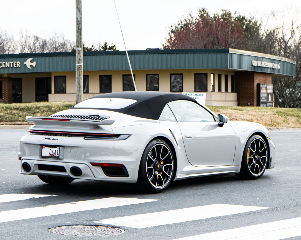 Porsche 911 992 Turbo S Cabriolet in silver, top down, showing modern styling and wide body