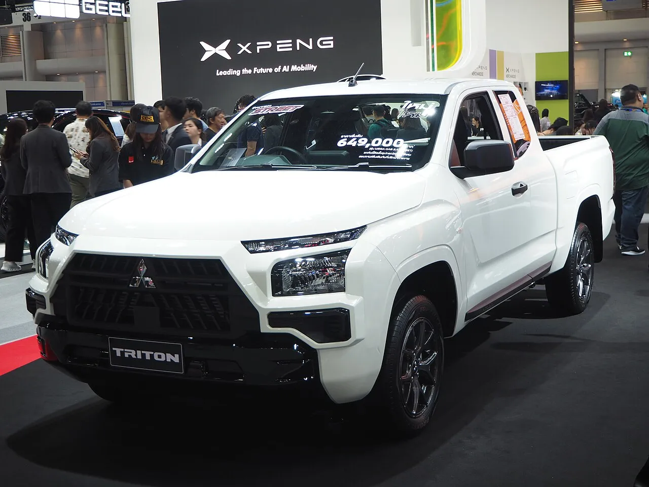 White Mitsubishi Triton pickup truck on display at a Thailand motor show