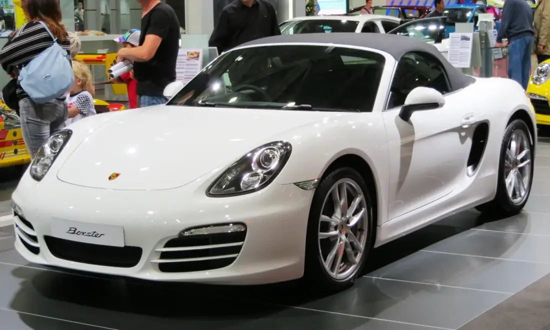 White 981 Porsche Boxster roadster with the roof raised at a car show