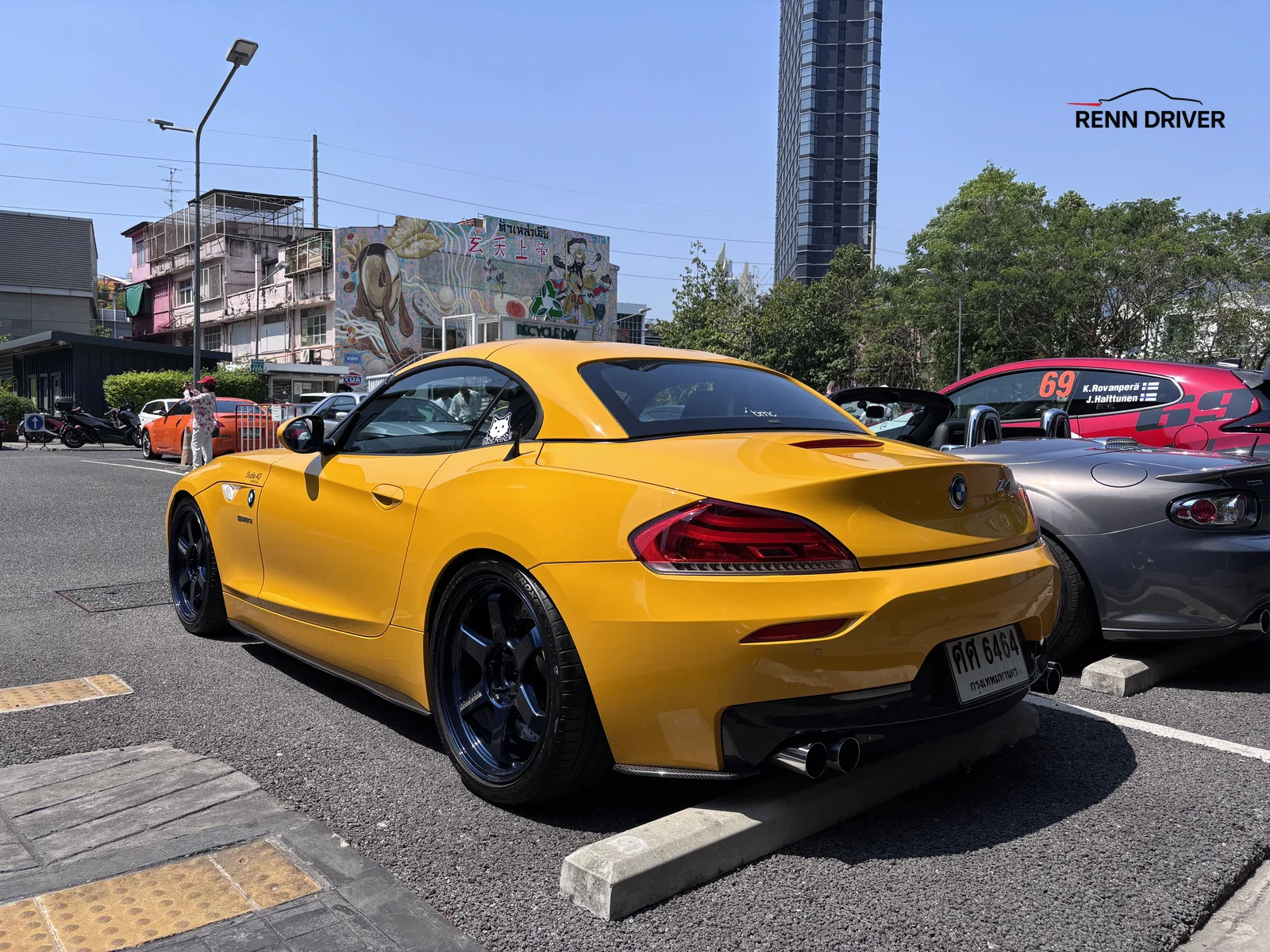 Yellow BMW Z4 with black wheels rear three quarter