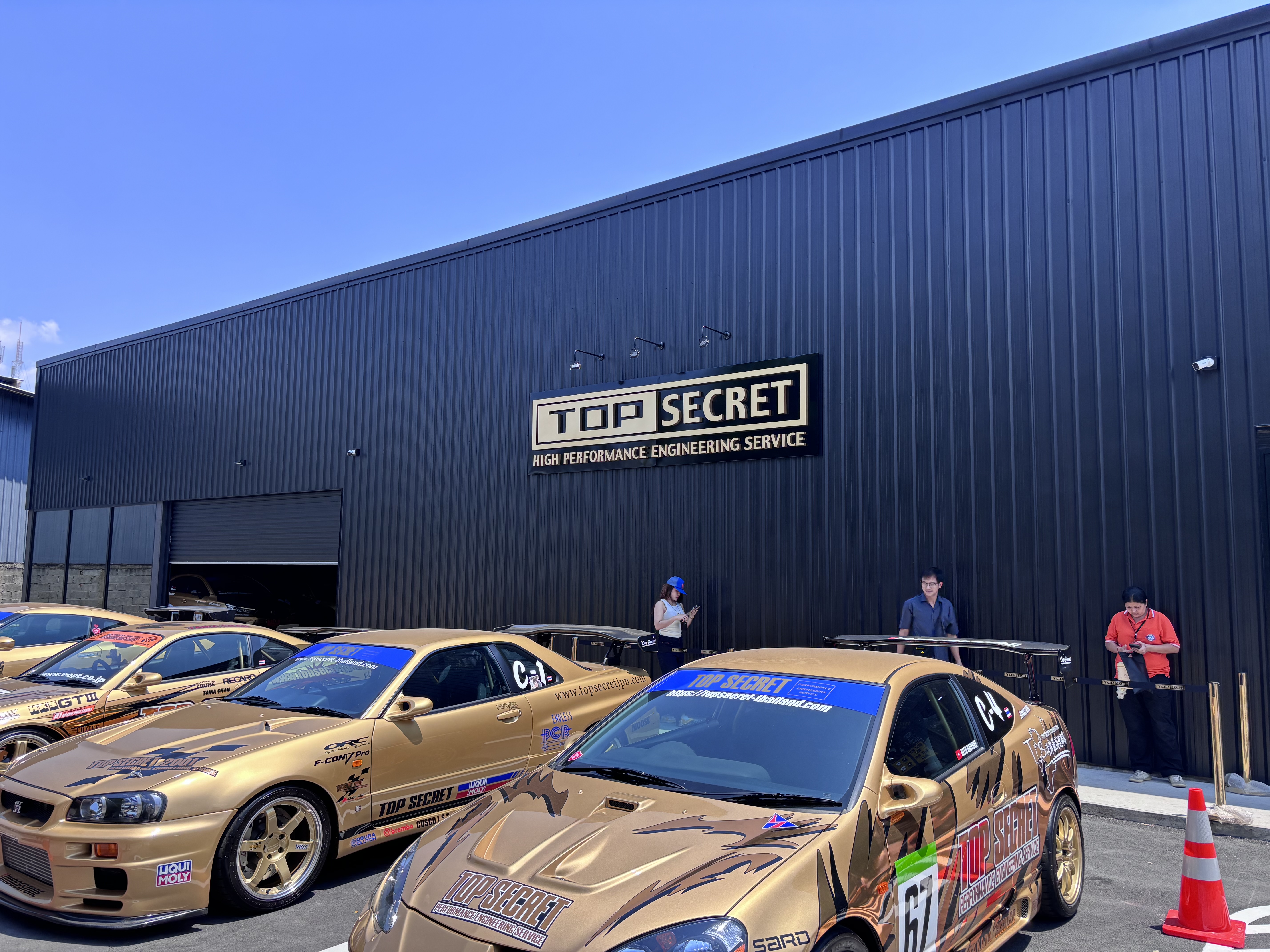 Gold Top Secret cars lined up outside the showroom