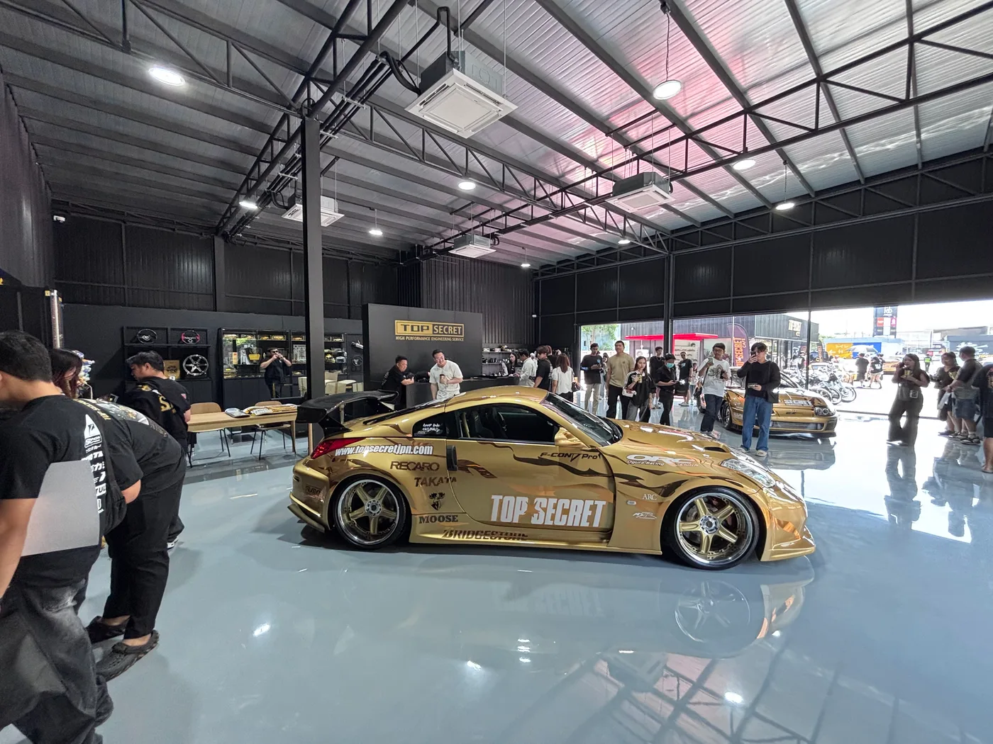 Gold Top Secret 350Z in the showroom surrounded by visitors